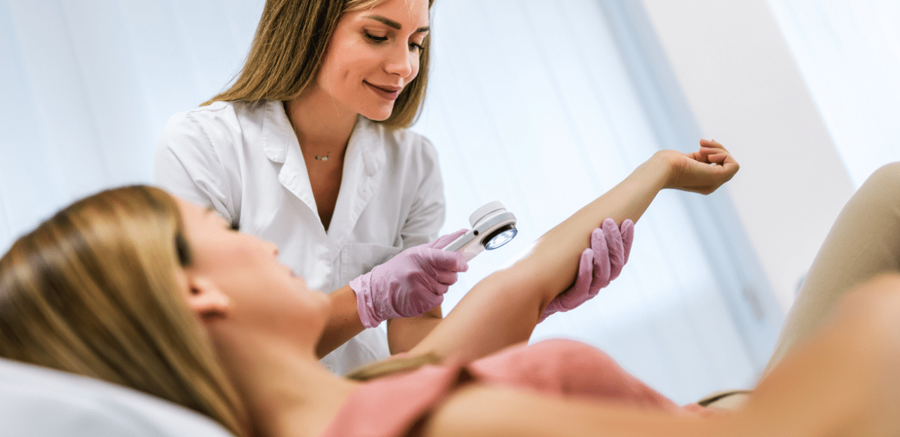 The dermatologist examines the moles or acne of the patient with a dermatoscope. Prevention of melanoma
