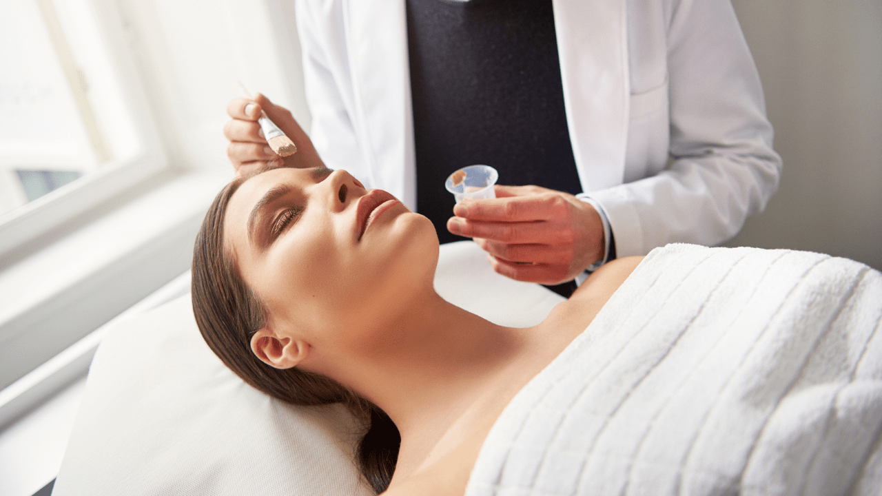 A woman receiving a facial treatment at a spa, with a relaxing expression on her face.