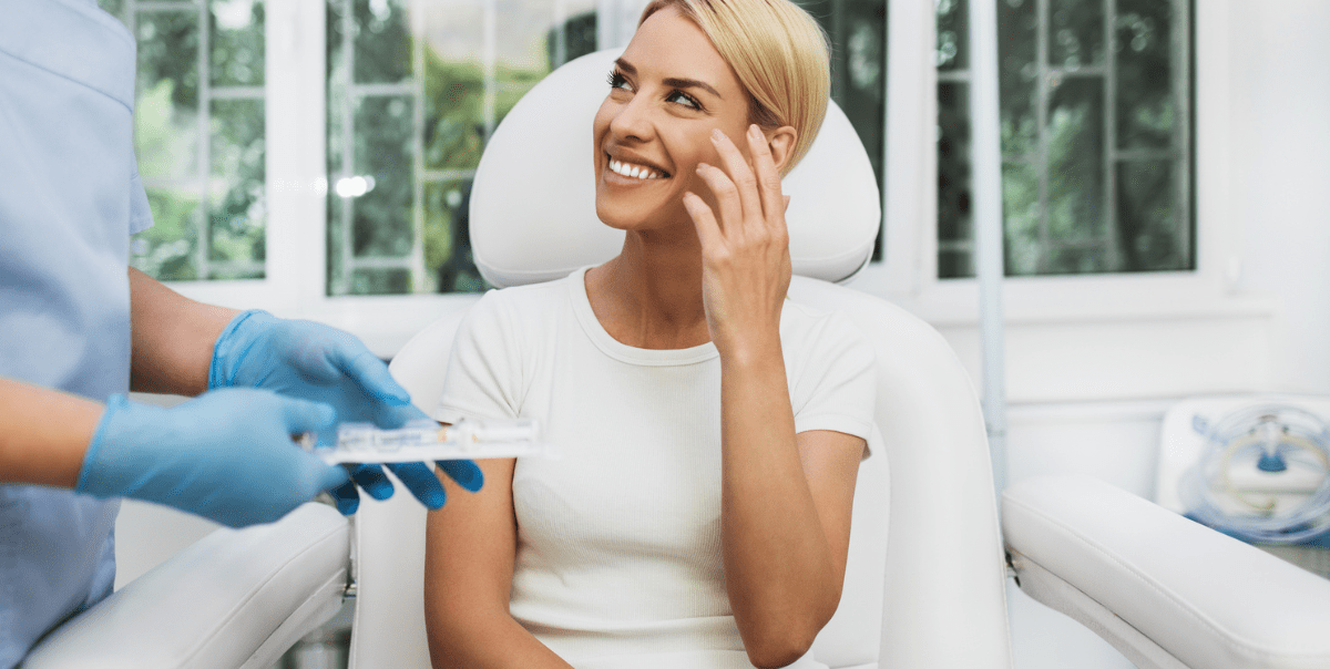 Woman sitting in medical chair, smiling during check-up.